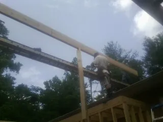 Carpenter setting a ridge beam over a new addition frame — Ice Dam Removal by Roofing Brothers in New Laguna