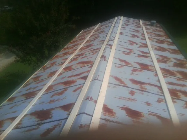 Rusted metal roof panels with new wood purlins before replacement — Storm Damage Roof Repair in New Laguna by Roofing Brothers